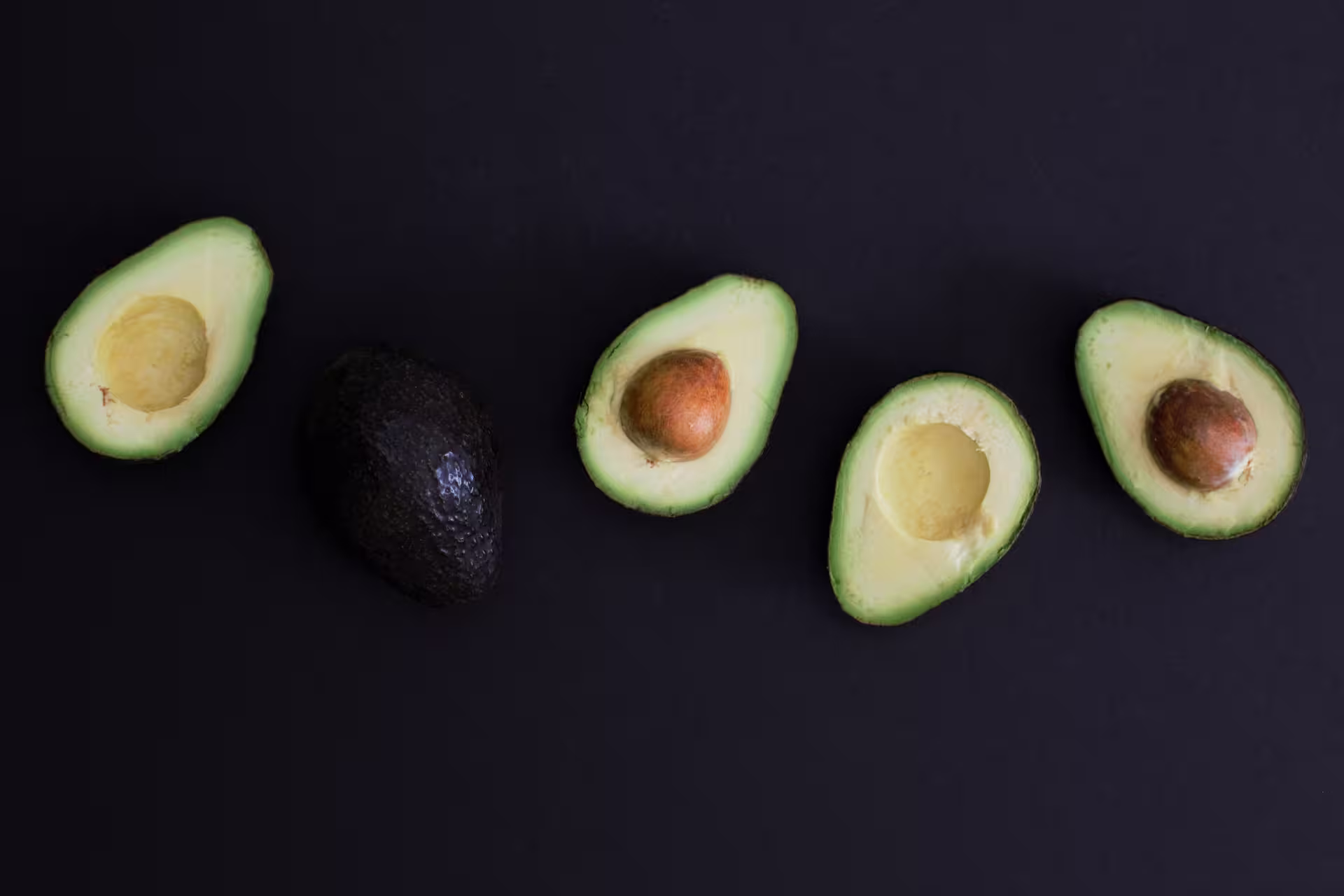 sliced avocado laid out on the black table